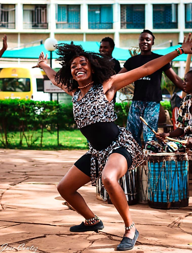 A Nafsi dancer performing in front of the drum line