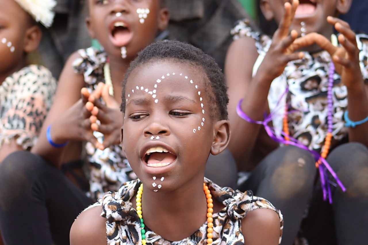 Children from a Nafsi centre singing together in face paint and costume