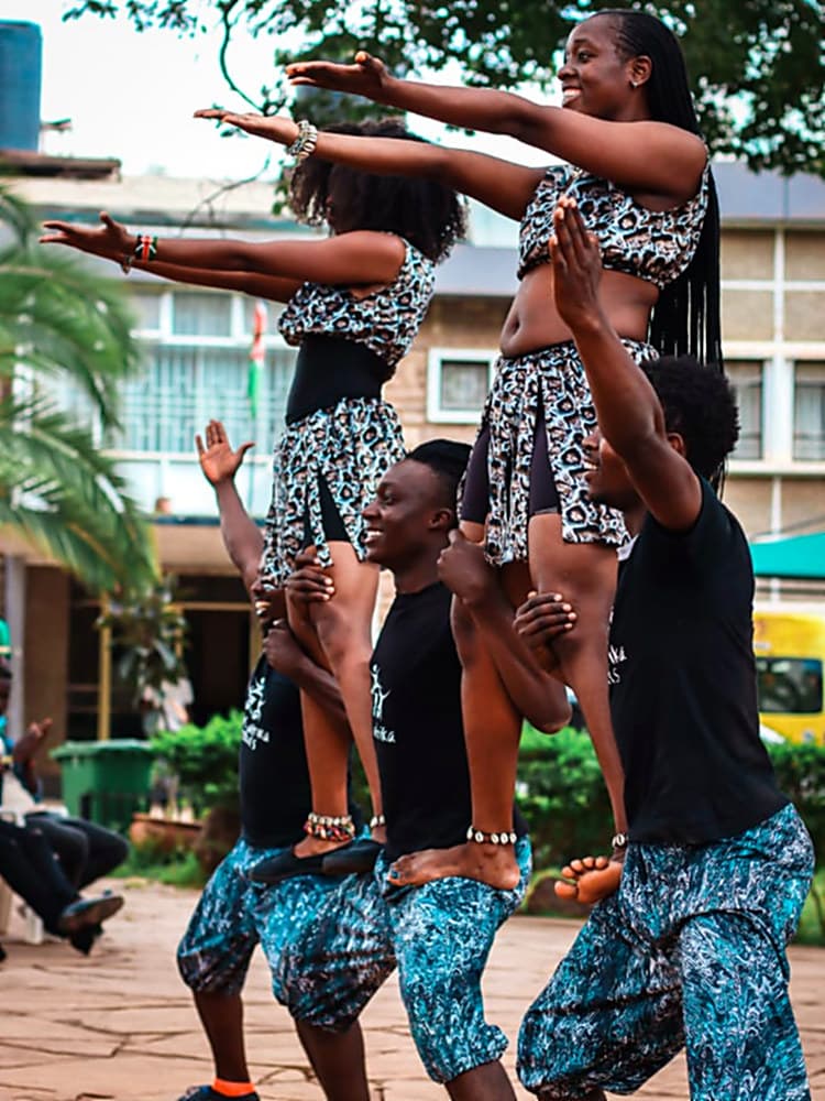Nafsi acrobats holding a pyramid during an outdoor performance in Nairobi